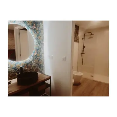 a bathroom with a mirror and a sink and a tub at Cosmevixia in Ourense