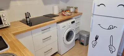 a kitchen with a washing machine and a refrigerator at Agradable apartamento a 2 minutos de la playa in Ares