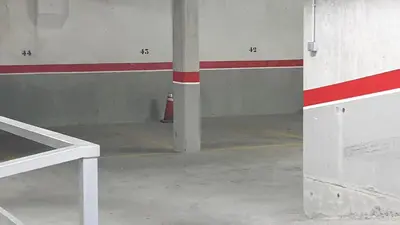an empty parking garage with a red and white wall at Agradable apartamento a 2 minutos de la playa in Ares