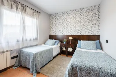 a bedroom with two beds and a window at Casa A Pedriña in Amés