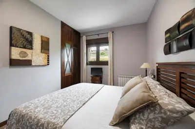 a bedroom with a large bed and a window at Casa A Pedriña in Amés