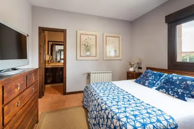 a bedroom with a bed and a flat screen tv at Casa A Pedriña in Amés