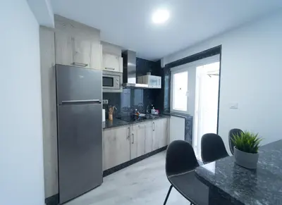 a kitchen with a refrigerator and a table with chairs at ApartmentoTerra de Augas 1 in Caldas de Reis