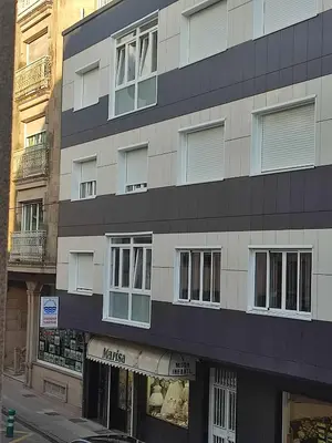 a tall building with windows on a city street at ApartmentoTerra de Augas 1 in Caldas de Reis
