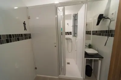 a white bathroom with a shower and a sink at ApartmentoTerra de Augas 1 in Caldas de Reis