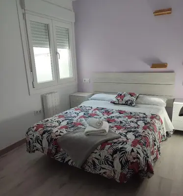 a bedroom with a bed with a comforter on it at ApartmentoTerra de Augas 1 in Caldas de Reis