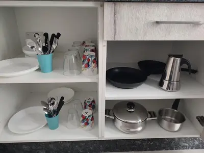 a cabinet with dishes and utensils in it at ApartmentoTerra de Augas 1 in Caldas de Reis