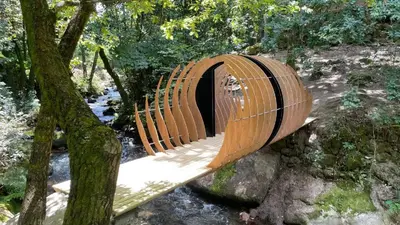 a wooden bridge in the middle of a forest at Casa Las Piedras in Padrenda