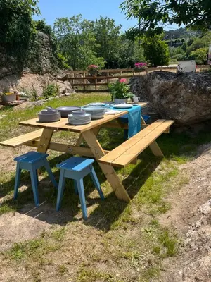 a picnic table and benches with plates and dishes on it at Casa Las Piedras in Padrenda