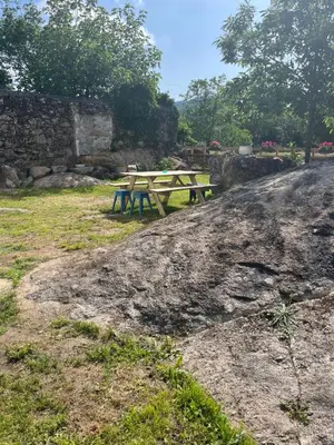a wooden picnic table sitting on top of a field at Casa Las Piedras in Padrenda