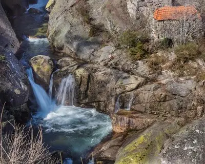 a waterfall on the side of a rocky mountain at Casa Las Piedras in Padrenda