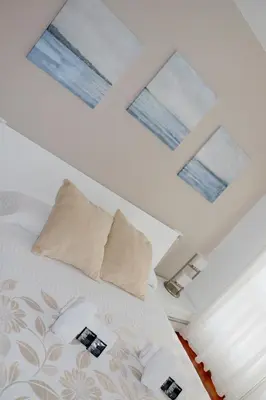 a bedroom with a bed with pillows and windows at ÁTICO DUPLEX CREDENCIAL in Sarria