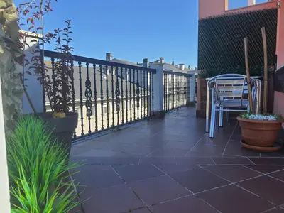a balcony with a black fence and a chair at ÁTICO DUPLEX CREDENCIAL in Sarria