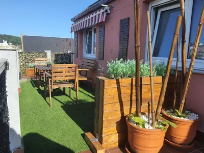 a patio with a table and chairs and potted plants at ÁTICO DUPLEX CREDENCIAL in Sarria