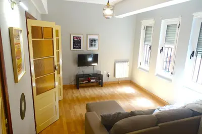 a living room with a couch and a television at Yellow Door 2 in Ponferrada