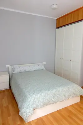 a bedroom with a bed and white cabinets at Yellow Door 2 in Ponferrada