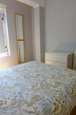 a bedroom with a bed with a blue and white bedspread at Yellow Door 2 in Ponferrada