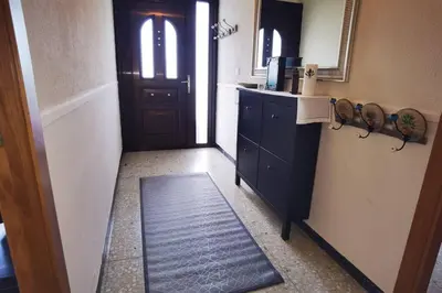 a hallway with a black cabinet and a door at Foz Acogedora casa familiar in Barrosa