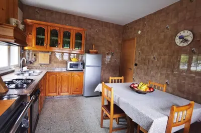 a kitchen with a table with a bowl of fruit on it at Foz Acogedora casa familiar in Barrosa