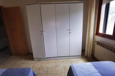 a bedroom with a white cabinet and a window at Foz Acogedora casa familiar in Barrosa