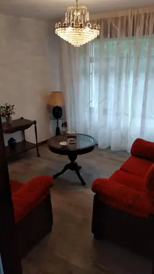a living room with a couch and a table and a chandelier at Piso en centro urbano de Puentedeume con terraza in Puentedeume