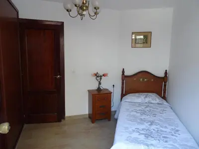 a bedroom with a bed and a dresser and a door at Piso en centro urbano de Puentedeume con terraza in Puentedeume