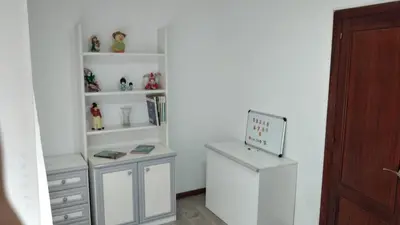 a room with white shelves and a desk with figurines at Piso en centro urbano de Puentedeume con terraza in Puentedeume