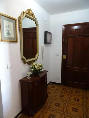 a hallway with a mirror and a dresser with flowers at Piso en centro urbano de Puentedeume con terraza in Puentedeume