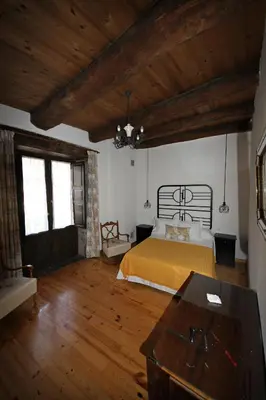 a bedroom with a bed and a wooden floor at CASA MAGUETO 2 noches mínimo in Toreno
