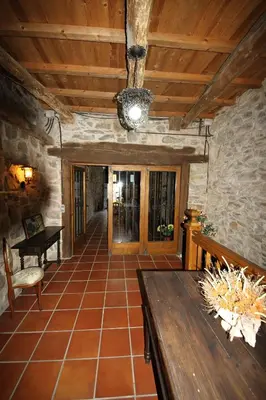 a living room with a table and a wooden ceiling at CASA MAGUETO 2 noches mínimo in Toreno