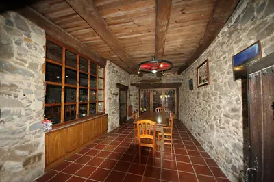 a dining room with a table and a stone wall at CASA MAGUETO 2 noches mínimo in Toreno