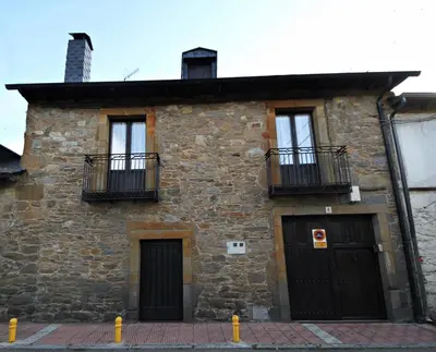 an old stone building with two doors and two balconies at CASA MAGUETO 2 noches mínimo in Toreno
