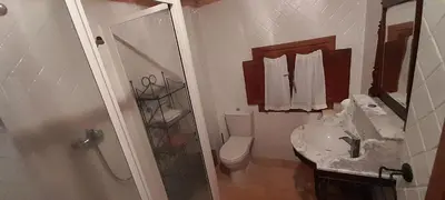 a bathroom with a toilet and a sink and a shower at Casa de Abril 2 in San Cristóbal de Valdueza