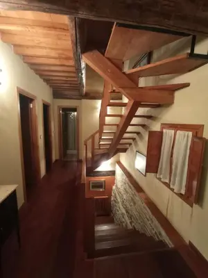 a hallway with wooden stairs in a house at Casa de Abril 2 in San Cristóbal de Valdueza