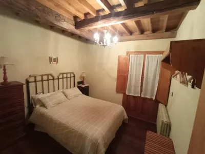 a bedroom with a bed and a chandelier at Casa de Abril 2 in San Cristóbal de Valdueza
