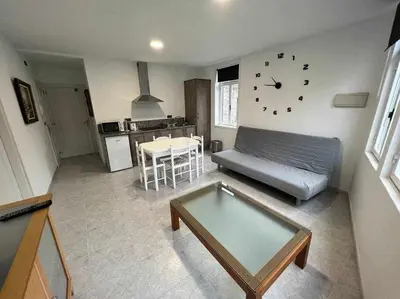a living room with a couch and a clock on the wall at Apartamento A in Irijoa