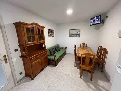 a dining room with a table and a room with a television at Apartamento A in Irijoa