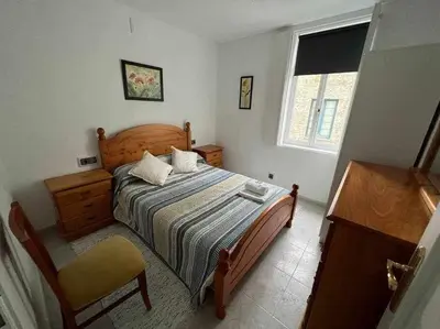a bedroom with a bed and a chair and a window at Apartamento A in Irijoa