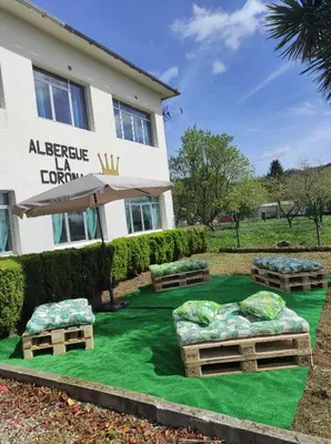 a hotel with three beds on a green lawn at Albergue La Corona1 in O Pino