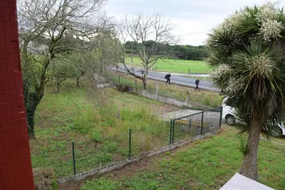 a view of a park with people walking on a road at Albergue La Corona1 in O Pino