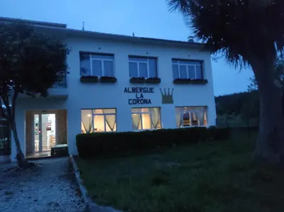 a building with a sign on the side of it at Albergue La Corona1 in O Pino