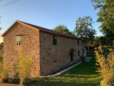 an old stone building with a grass yard at Casa Fogar do Ulla in Vedra