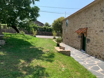 a brick building with a grassy yard next to a street at Casa Fogar do Ulla in Vedra