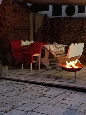 a patio with a table and chairs and a fire pit at A Casa do Abuelo in Ourense