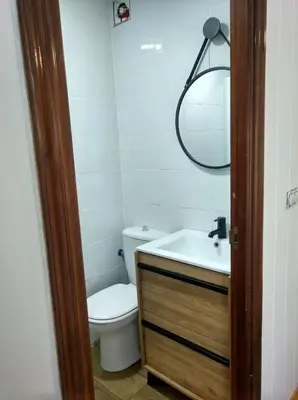 a bathroom with a toilet and a sink and a mirror at Céntrico Estudio in Sada