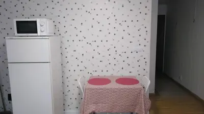a kitchen with a table and a white refrigerator at Céntrico Estudio in Sada