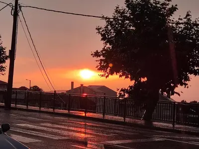 a sunset over a parking lot with a tree at Fogar Rivoira Sacrata in Castro Caldelas
