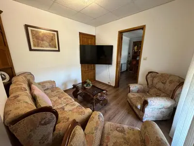 a living room with couches and a flat screen tv at Fogar Rivoira Sacrata in Castro Caldelas