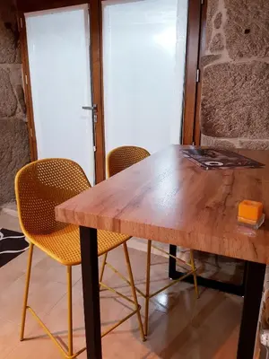 a wooden table and chairs in a room at A aira da xoaniña in Allariz