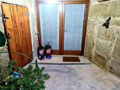 a living room with a couch and a stone wall at A aira da xoaniña in Allariz